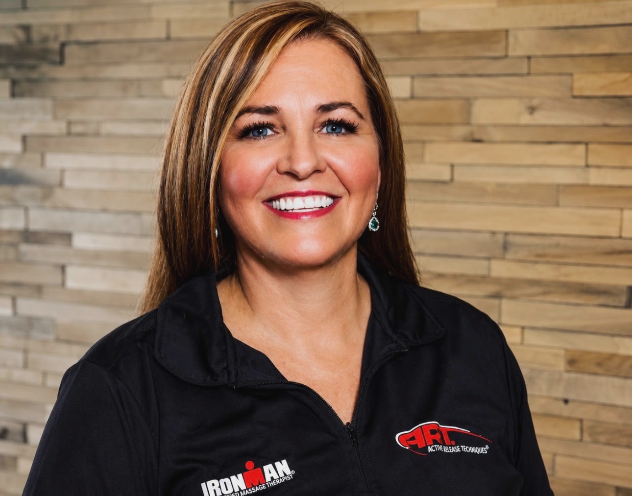 Shelly Lindell standing beside a massage table with the mountain view behind her